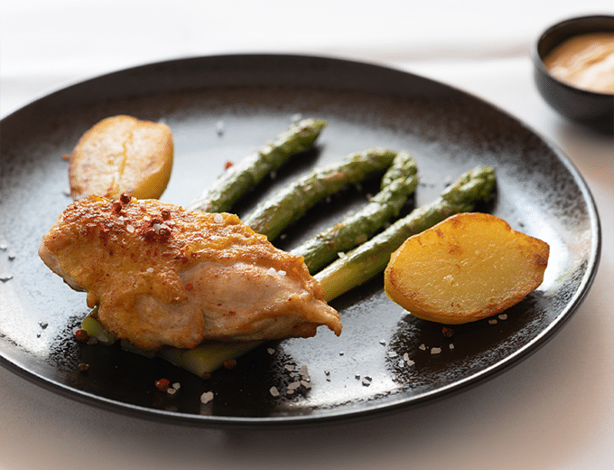 Dish with green asparagus, potatoes, and sauce at Restaurant Belchenblick